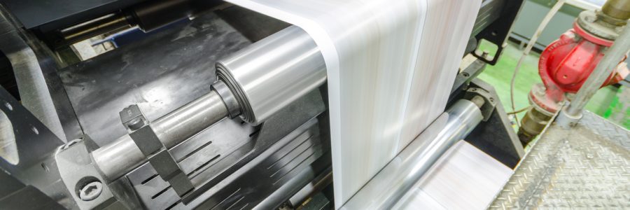 A printing press executing an order from the web to print workflow by printing a long strip, which is blurred by the speed of the print job.